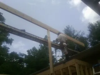 Carpenter setting a ridge beam over a new addition frame — Ice Dam Removal by Roofing Brothers in Worley