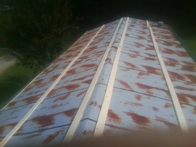 Rusted metal roof panels with new wood purlins before replacement — Storm Damage Roof Repair in Worley by Roofing Brothers