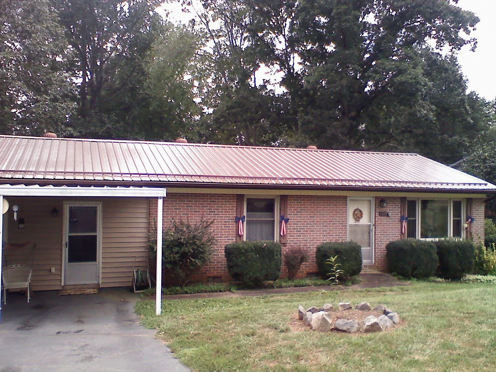 Bronze metal roof and carport on a brick ranch home — Roof Repair work by our crew in Worley