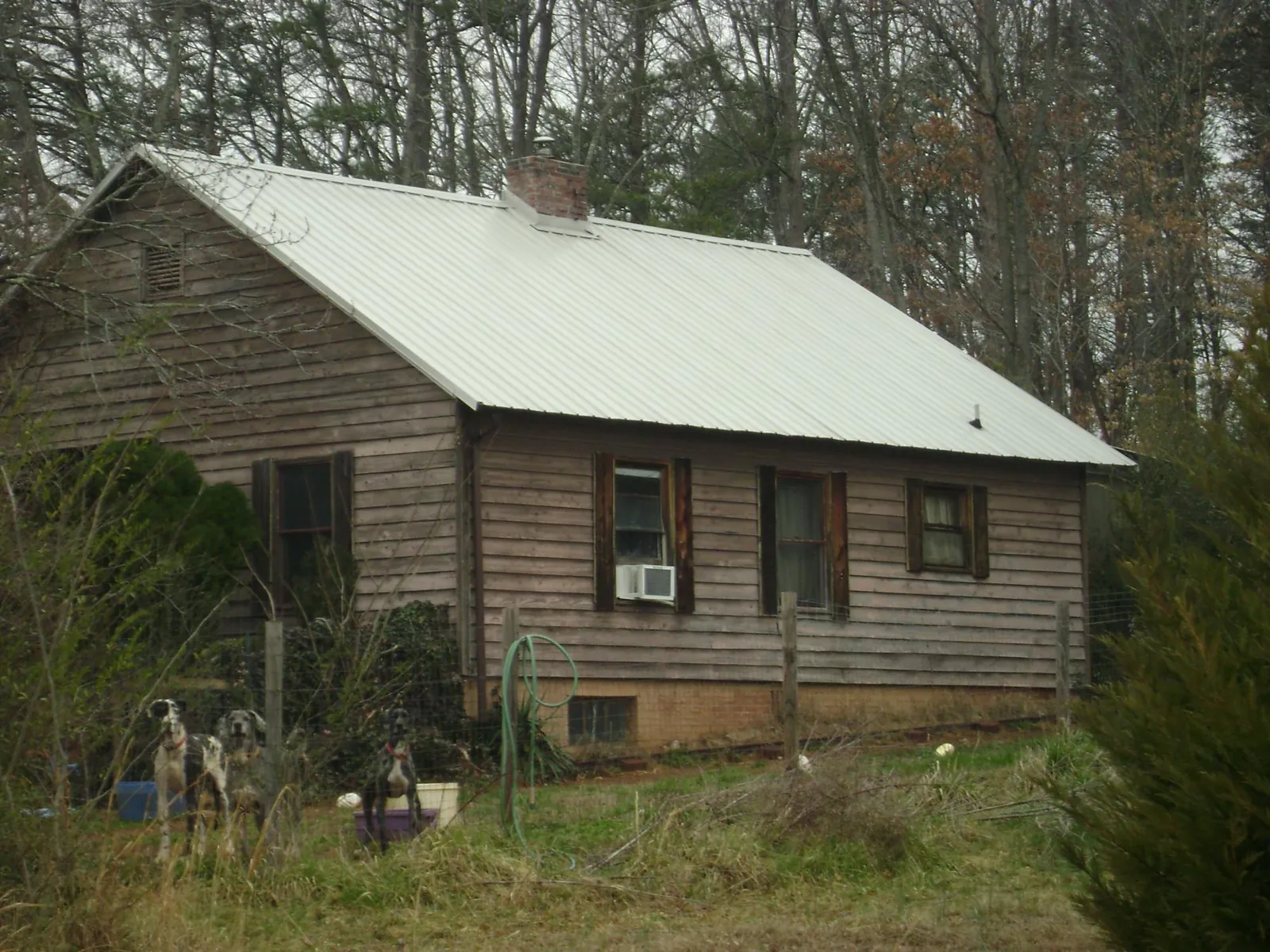 White metal roof on an old wood sided farmhouse, from a Metal Roof Installation job in Worley